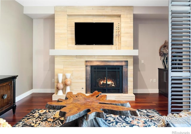 living room with dark hardwood / wood-style floors and a large fireplace