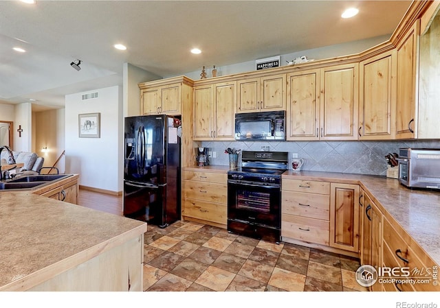 kitchen featuring recessed lighting, a sink, visible vents, decorative backsplash, and black appliances