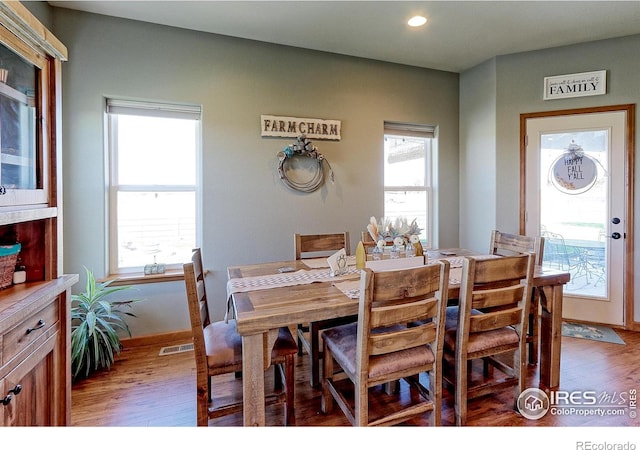 dining room featuring a wealth of natural light, light wood-style flooring, and visible vents