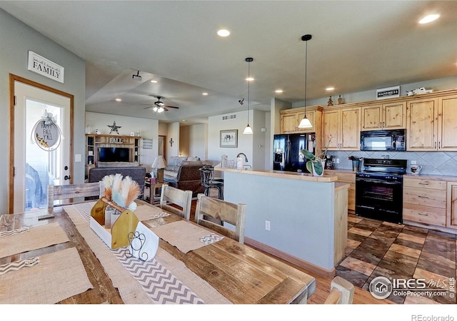 kitchen with black appliances, light countertops, decorative light fixtures, and open floor plan