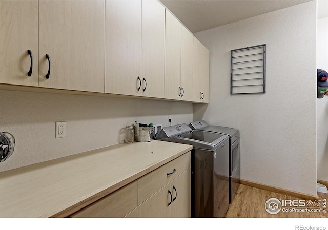 laundry area with light wood-style floors, cabinet space, independent washer and dryer, and baseboards