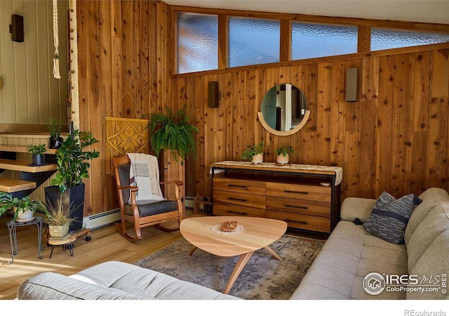 living room featuring lofted ceiling with beams, wood walls, baseboard heating, and hardwood / wood-style flooring