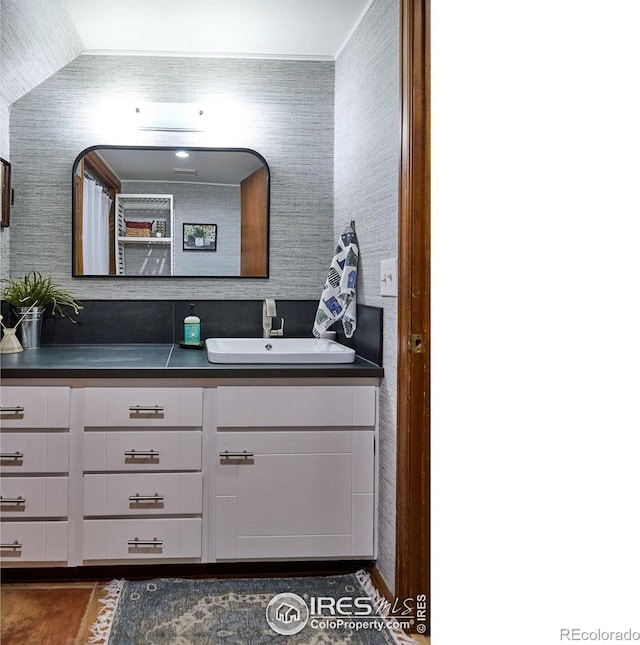 bathroom featuring vanity, lofted ceiling, and tile patterned flooring