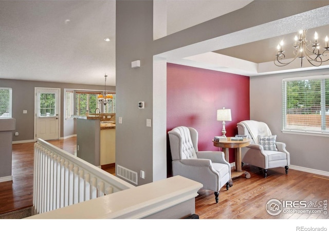 sitting room with a notable chandelier, hardwood / wood-style floors, and sink