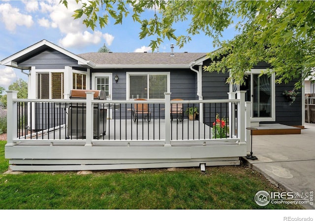 rear view of house featuring a wooden deck