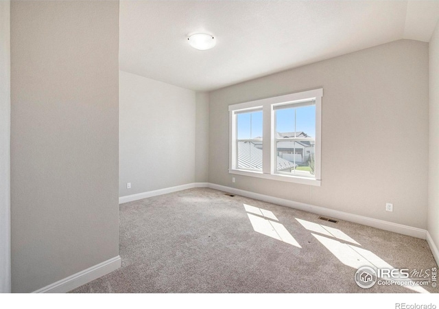 empty room with lofted ceiling and carpet flooring