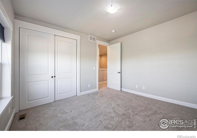 unfurnished bedroom featuring carpet and a closet