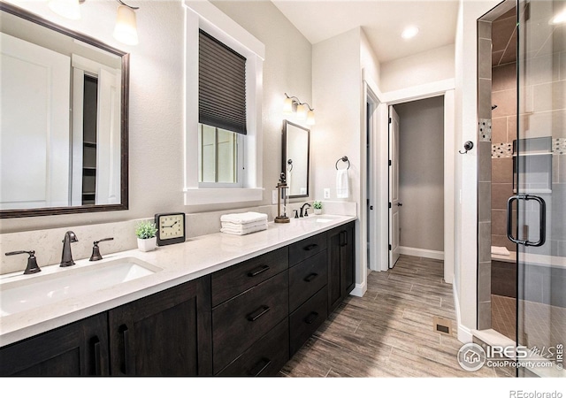 bathroom featuring vanity, hardwood / wood-style floors, and a shower with shower door