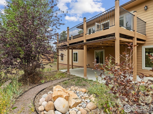 rear view of house featuring a patio and a balcony