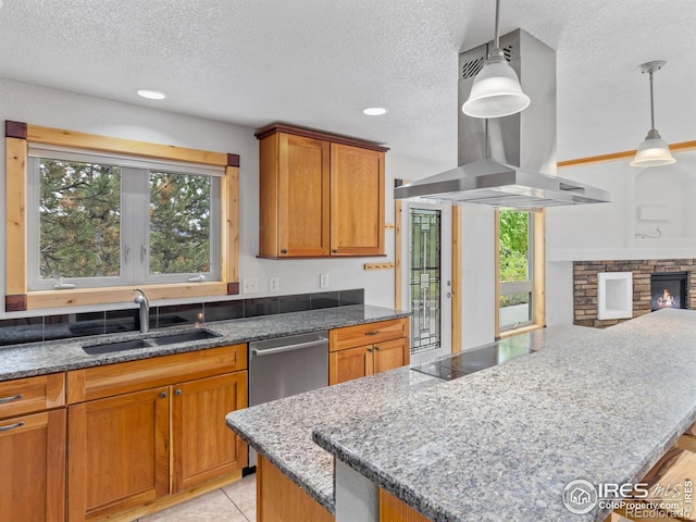 kitchen with island range hood, sink, a fireplace, and a textured ceiling