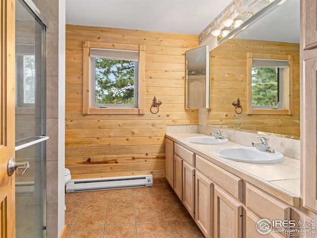 bathroom with wood walls, a baseboard radiator, a shower with shower door, vanity, and toilet