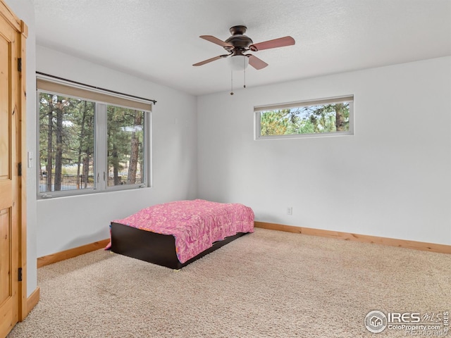 bedroom featuring a textured ceiling, carpet flooring, and ceiling fan