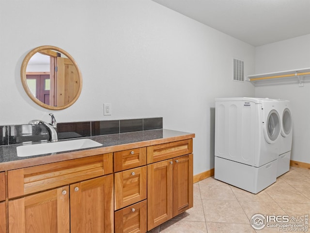 laundry room featuring light tile patterned floors, sink, and washing machine and clothes dryer