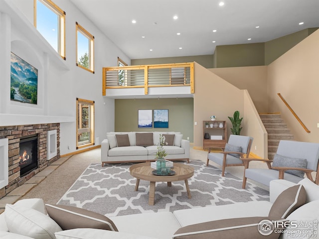 carpeted living room with a fireplace and a towering ceiling