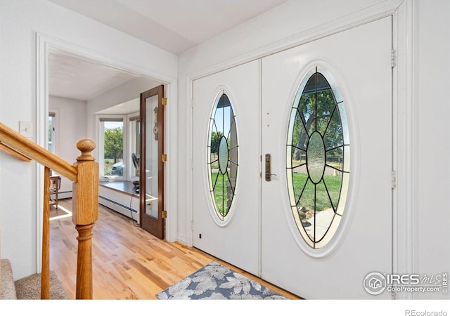 foyer featuring stairway, a baseboard radiator, french doors, and light wood-style floors