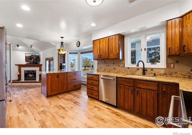 kitchen with a sink, open floor plan, backsplash, brown cabinets, and dishwasher