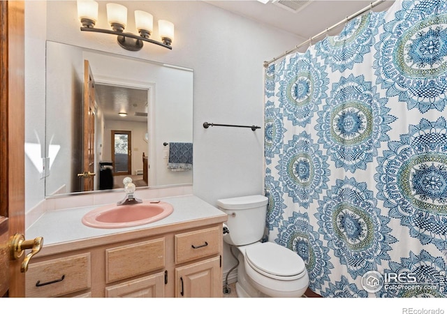 bathroom with vanity, a shower with shower curtain, and toilet