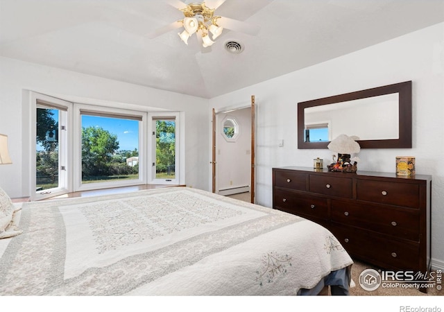 bedroom with a baseboard heating unit, a ceiling fan, multiple windows, and visible vents