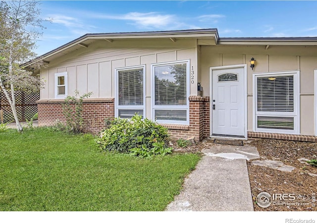 doorway to property with a lawn