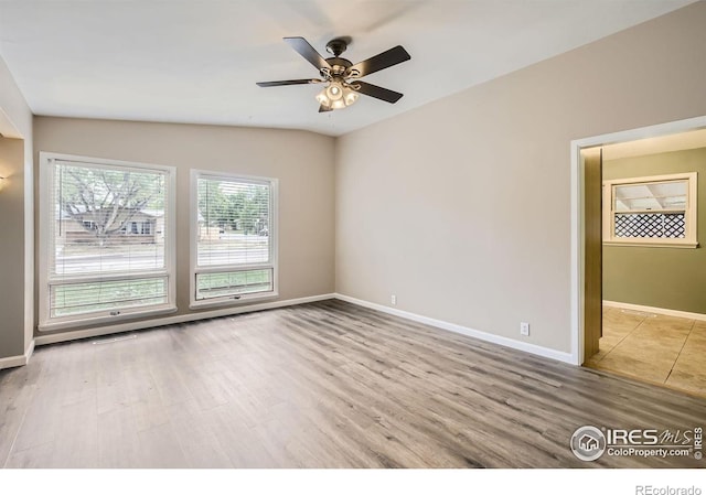 spare room featuring lofted ceiling, wood-type flooring, and ceiling fan