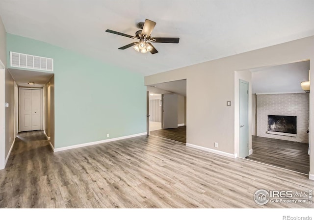 unfurnished living room featuring ceiling fan, a fireplace, and hardwood / wood-style floors