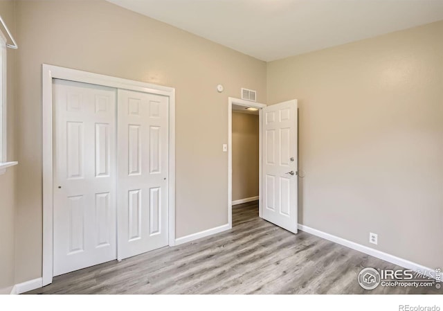 unfurnished bedroom featuring a closet and light wood-type flooring