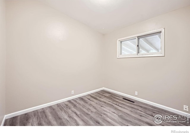 unfurnished room with hardwood / wood-style flooring