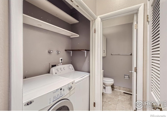 washroom with independent washer and dryer and light tile patterned floors