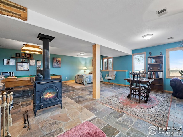 living room featuring a wood stove and a textured ceiling