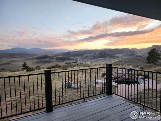 deck at dusk featuring a mountain view