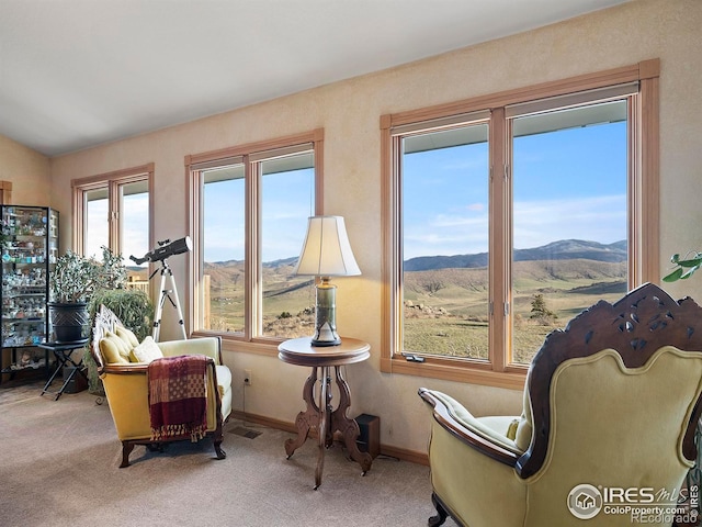 sitting room with a mountain view, light carpet, and lofted ceiling