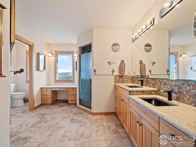 bathroom with backsplash, vanity, and toilet