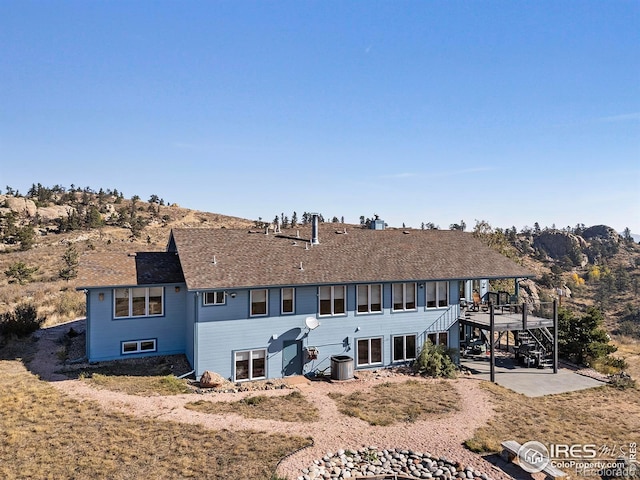 rear view of property featuring cooling unit, a patio area, and a wooden deck