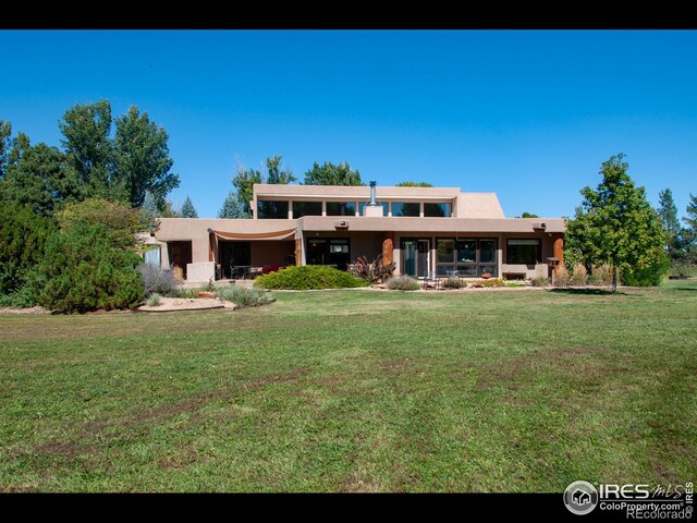 rear view of property with a yard