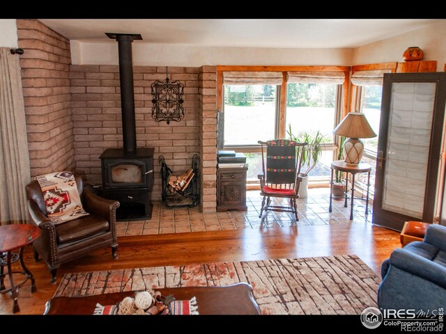 living room with light hardwood / wood-style floors and a wood stove