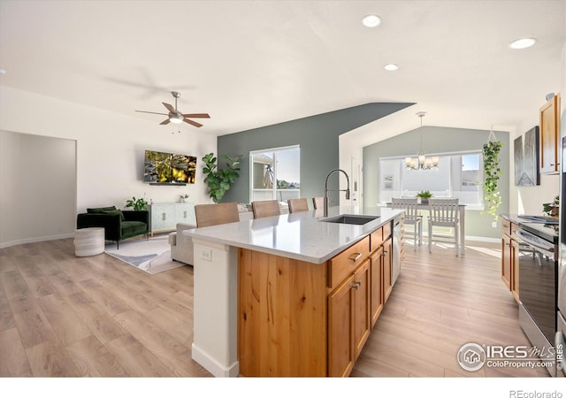 kitchen featuring ceiling fan with notable chandelier, a wealth of natural light, hanging light fixtures, and sink