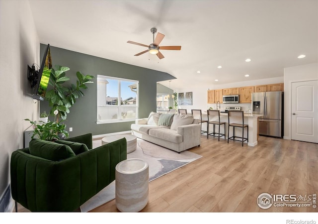 living room featuring light hardwood / wood-style floors and ceiling fan