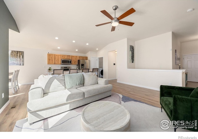 living room with light hardwood / wood-style flooring, vaulted ceiling, and ceiling fan