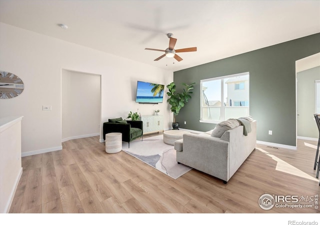 living room featuring light hardwood / wood-style floors and ceiling fan