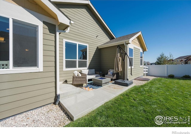 exterior space with a yard, an outdoor living space with a fire pit, and a patio area