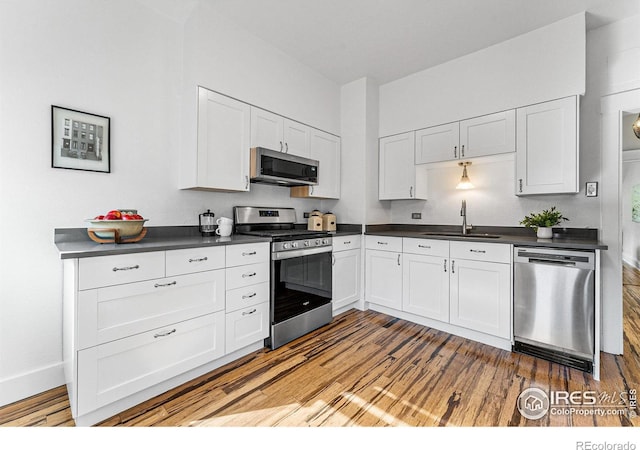 kitchen featuring appliances with stainless steel finishes, light hardwood / wood-style flooring, sink, and white cabinets