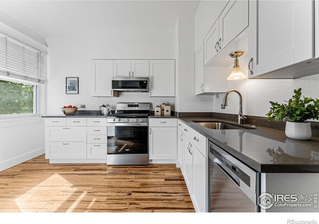 kitchen featuring light hardwood / wood-style flooring, appliances with stainless steel finishes, sink, and white cabinetry