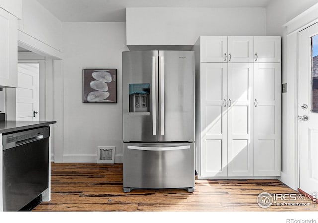 kitchen with light hardwood / wood-style floors, appliances with stainless steel finishes, and white cabinetry