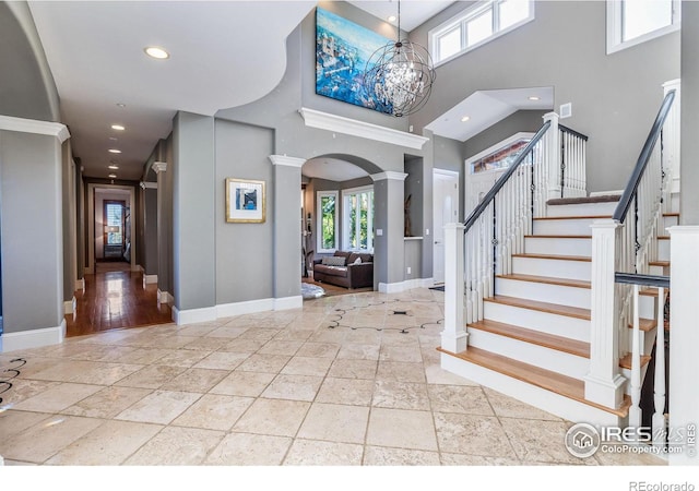 8001 Fairview Rd, Boulder, CO 80303 - foyer entrance featuring ornate columns, baseboards, stone tile floors, a towering ceiling, and recessed lighting