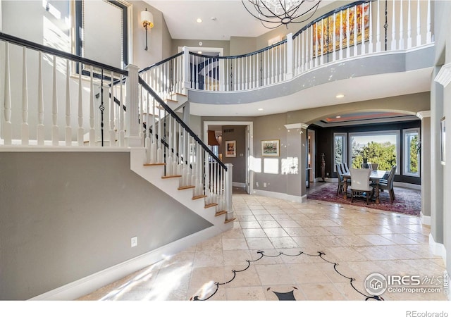 8001 Fairview Rd, Boulder, CO 80303 - foyer entrance with baseboards, ornate columns, arched walkways, a towering ceiling, and stairway