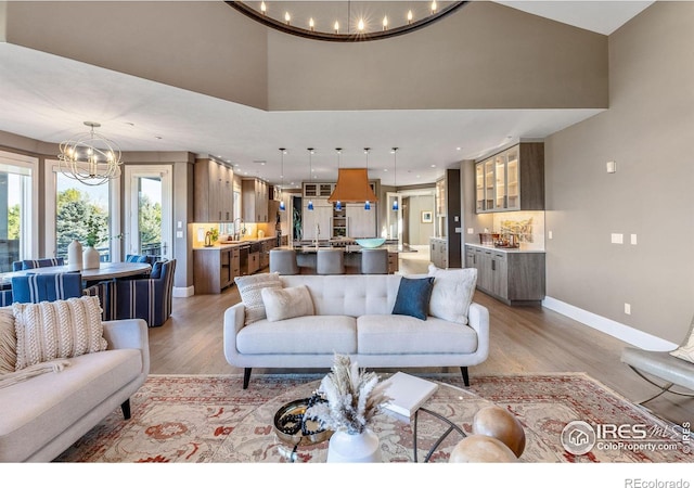 8001 Fairview Rd, Boulder, CO 80303 - living area featuring a chandelier, light wood-type flooring, baseboards, a towering ceiling, and recessed lighting