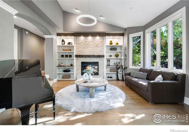 8001 Fairview Rd, Boulder, CO 80303 - living area featuring vaulted ceiling, light wood finished floors, built in shelves, a fireplace, and arched walkways