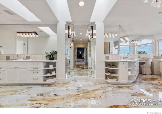 8001 Fairview Rd, Boulder, CO 80303 - full bathroom featuring marble tiled floors, vanity, decorative backsplash, recessed lighting, and a chandelier
