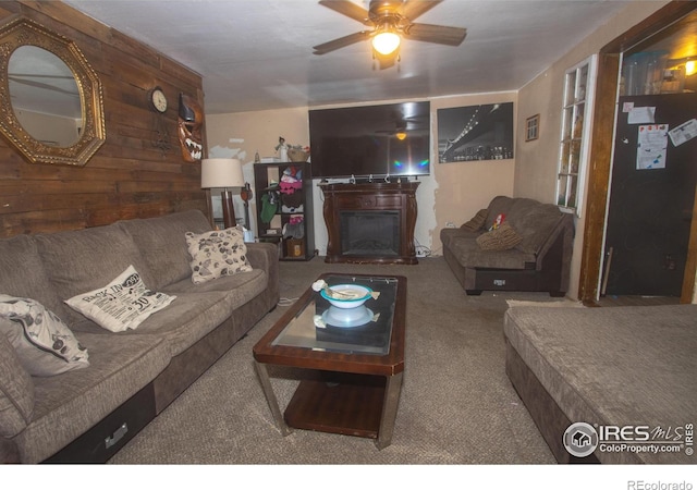 carpeted living room with wooden walls and ceiling fan