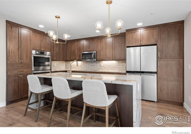 kitchen with pendant lighting, an inviting chandelier, and stainless steel appliances